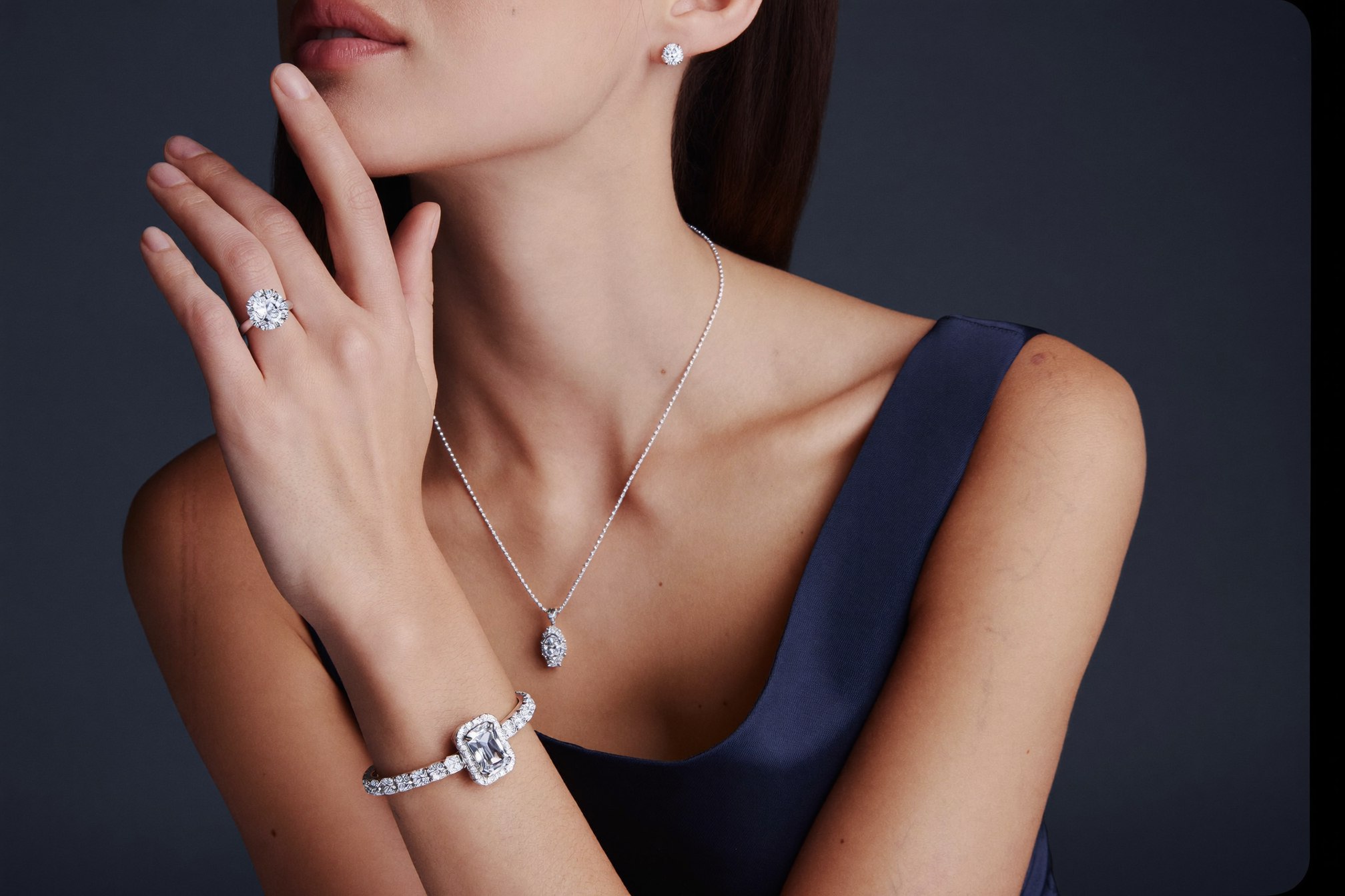 Elegant woman wearing a complete lab-grown diamond set — ring, bracelet, earrings and necklace